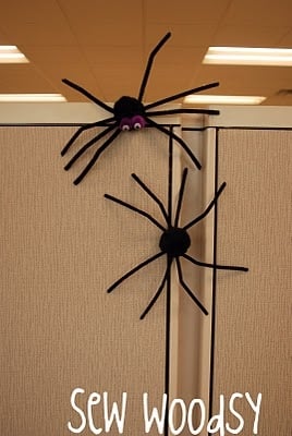 Two pipe cleaner spiders on a magnetic wall.