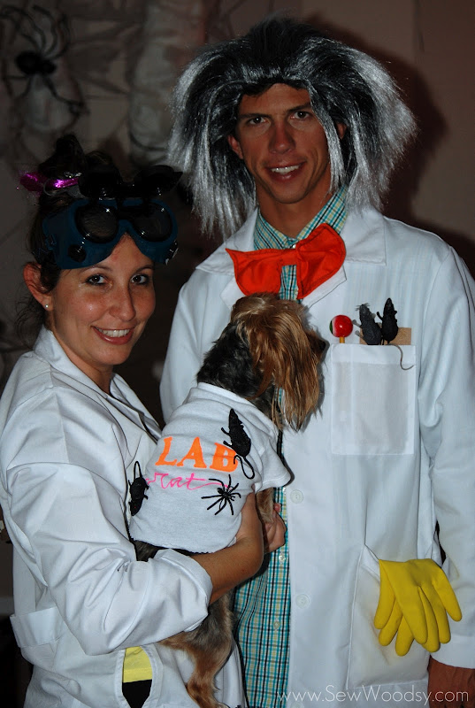 Man and woman in lab coats holding a dog. 