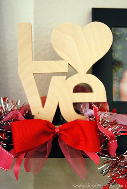 Wooden love sign with garland tied to it.