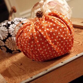 Orange cloth pumpkin on a wood crate.