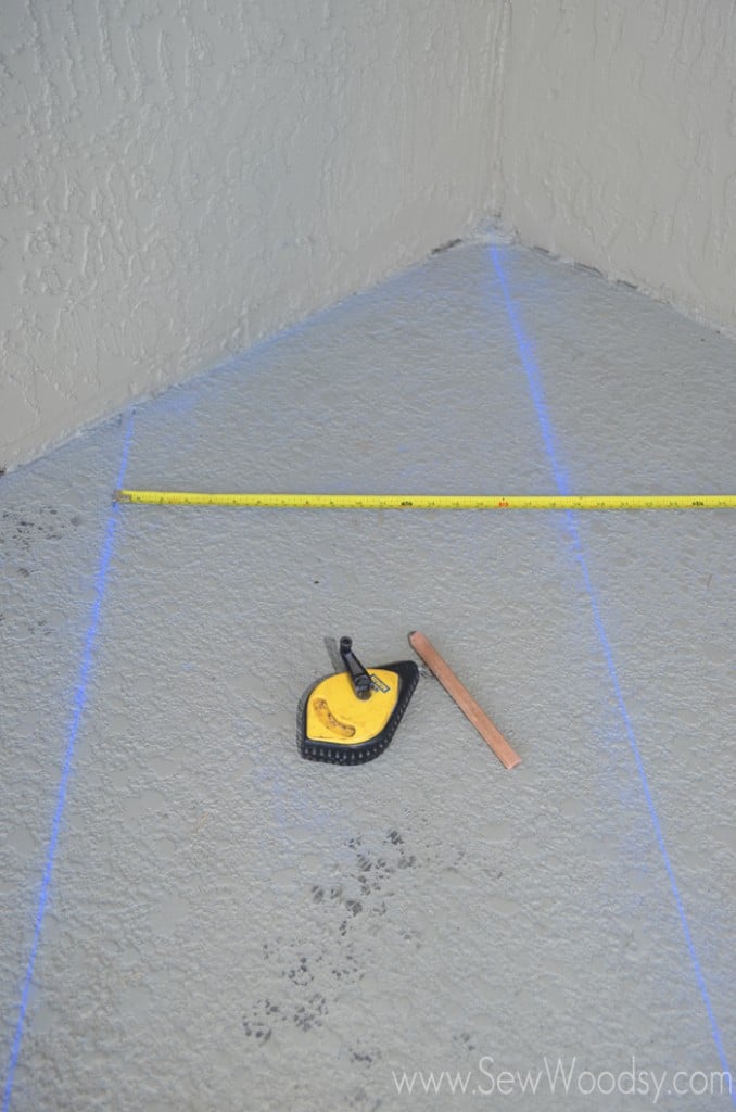 Measuring tape with chalk lines on a patio floor.