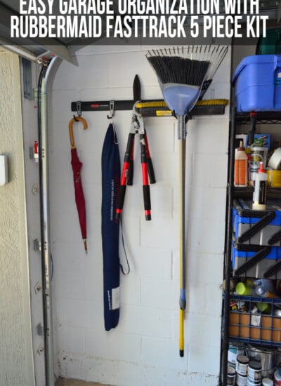 Fasttrack system on a garage wall holding a broom, hedge clippers, and umbrellas with blog post text on photo.