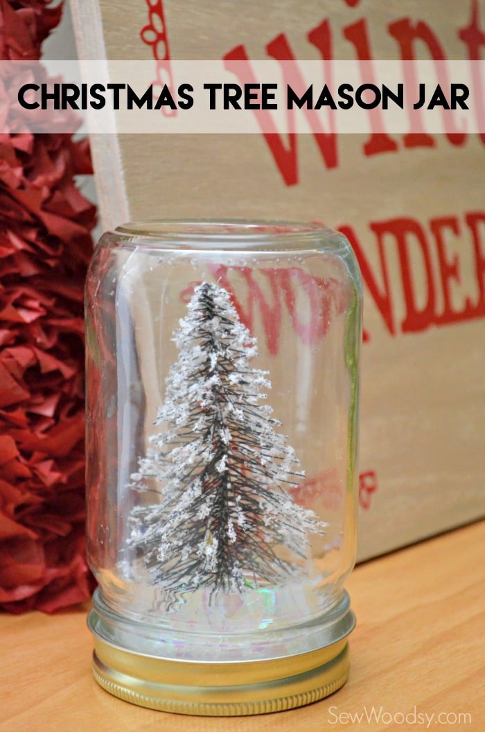 Glass mason jar filled with fake snow and a wire bottle brush tree with text on image for Pinterest.