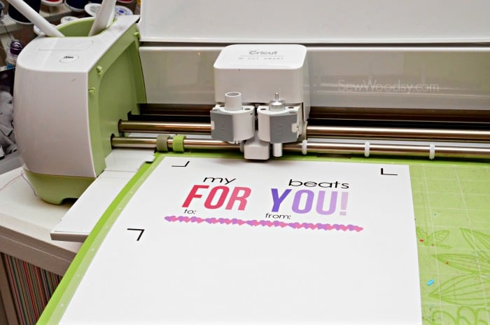 Cricut machine with green mat and colorful valentine.