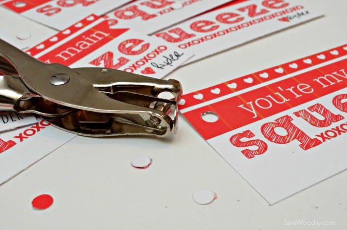 Hole punch with holes punched out of valentines.