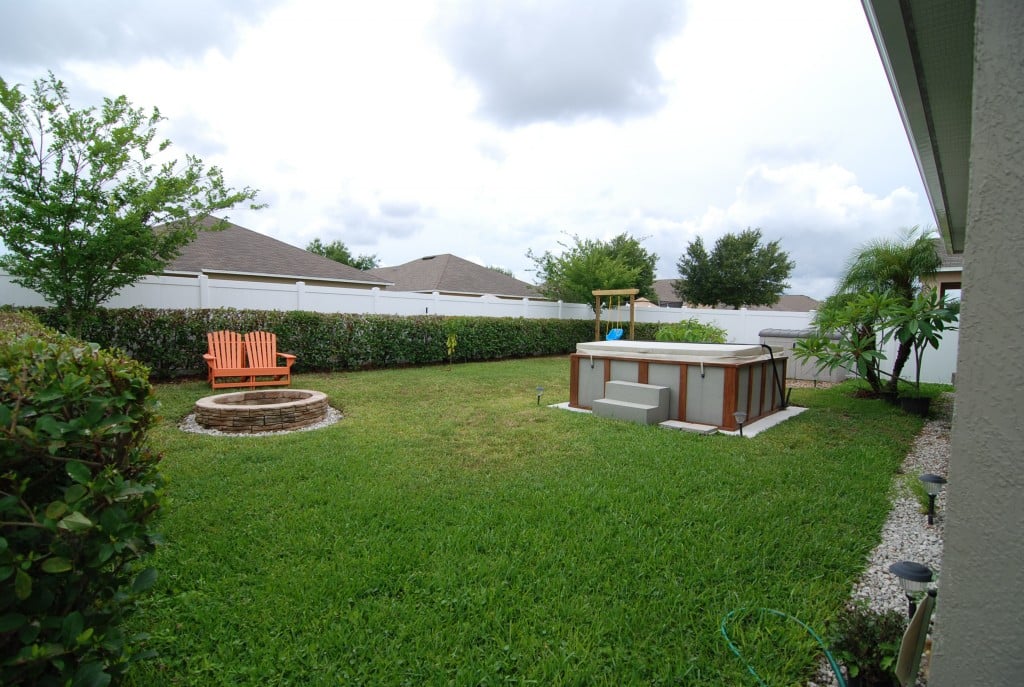 back yard with hot tub and fire place