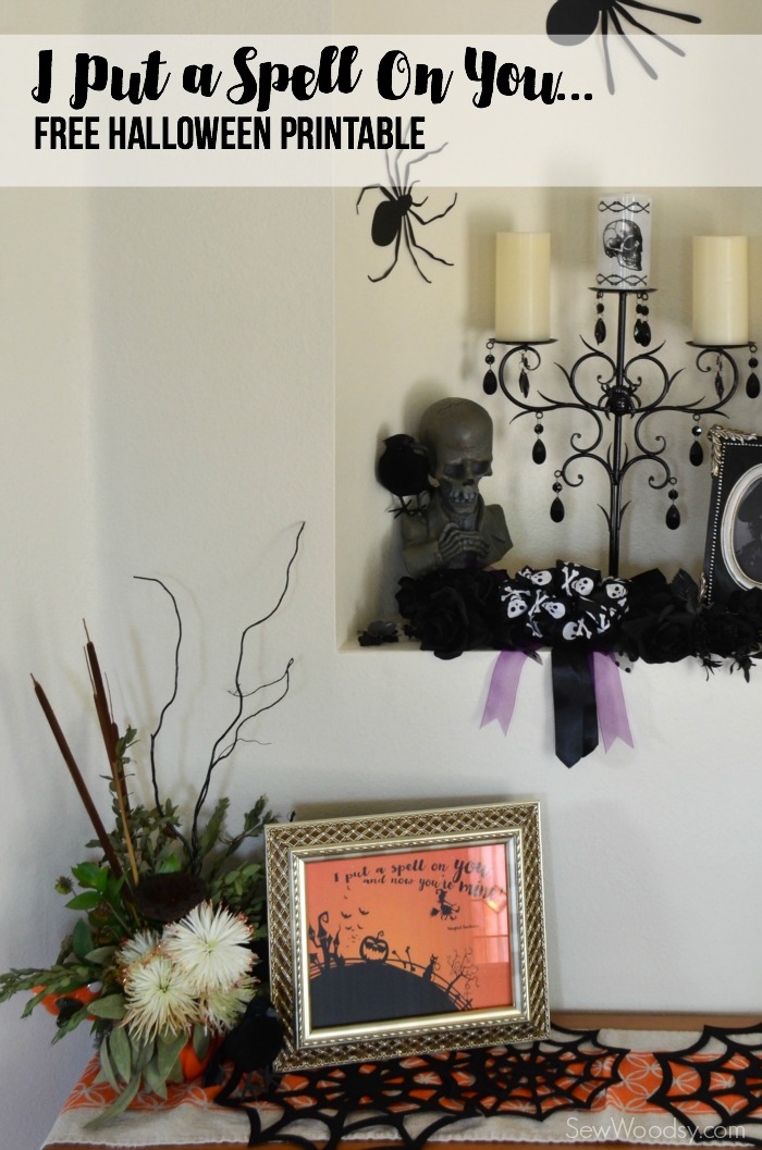 Wall with spiders, Halloween decor, plant, and frame that reads "I put a spell on you".