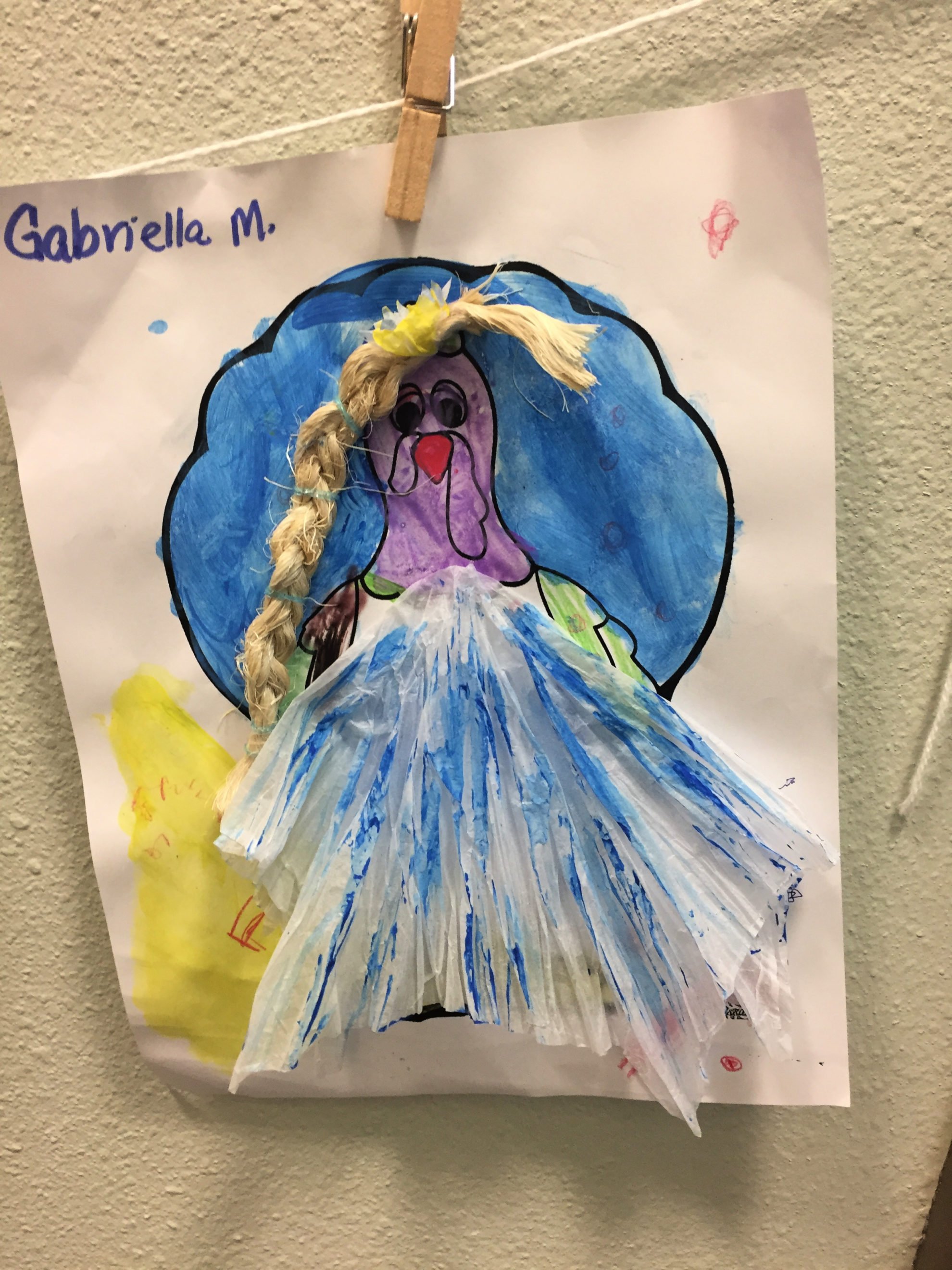 Paper Turkey In Disguise dressed as Elsa with a white and blue tissue paper dress, and a braided rope for hair.