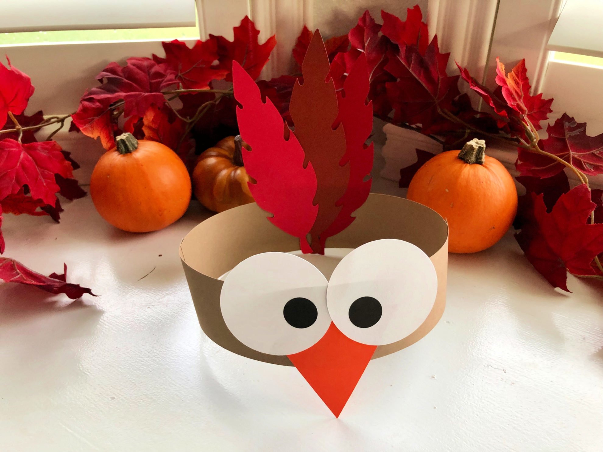 Turkey Paper Headband with fall leaves in the background.