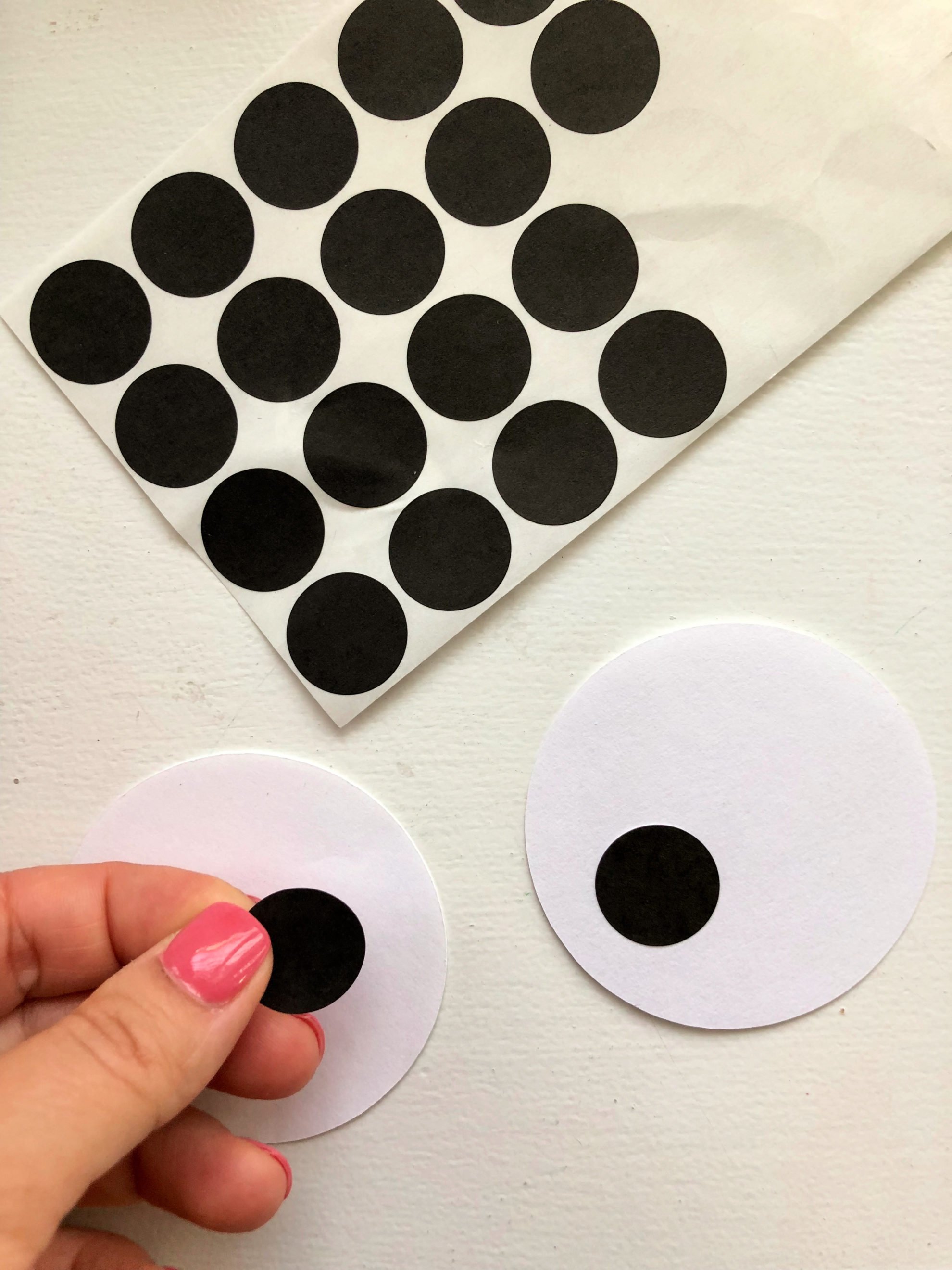 Black avery dot stickers pressed on to white circle paper cut outs.