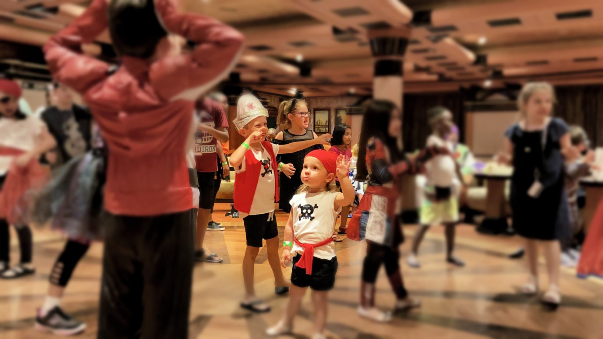 Little girl dressed as a pirate on a dance floor.