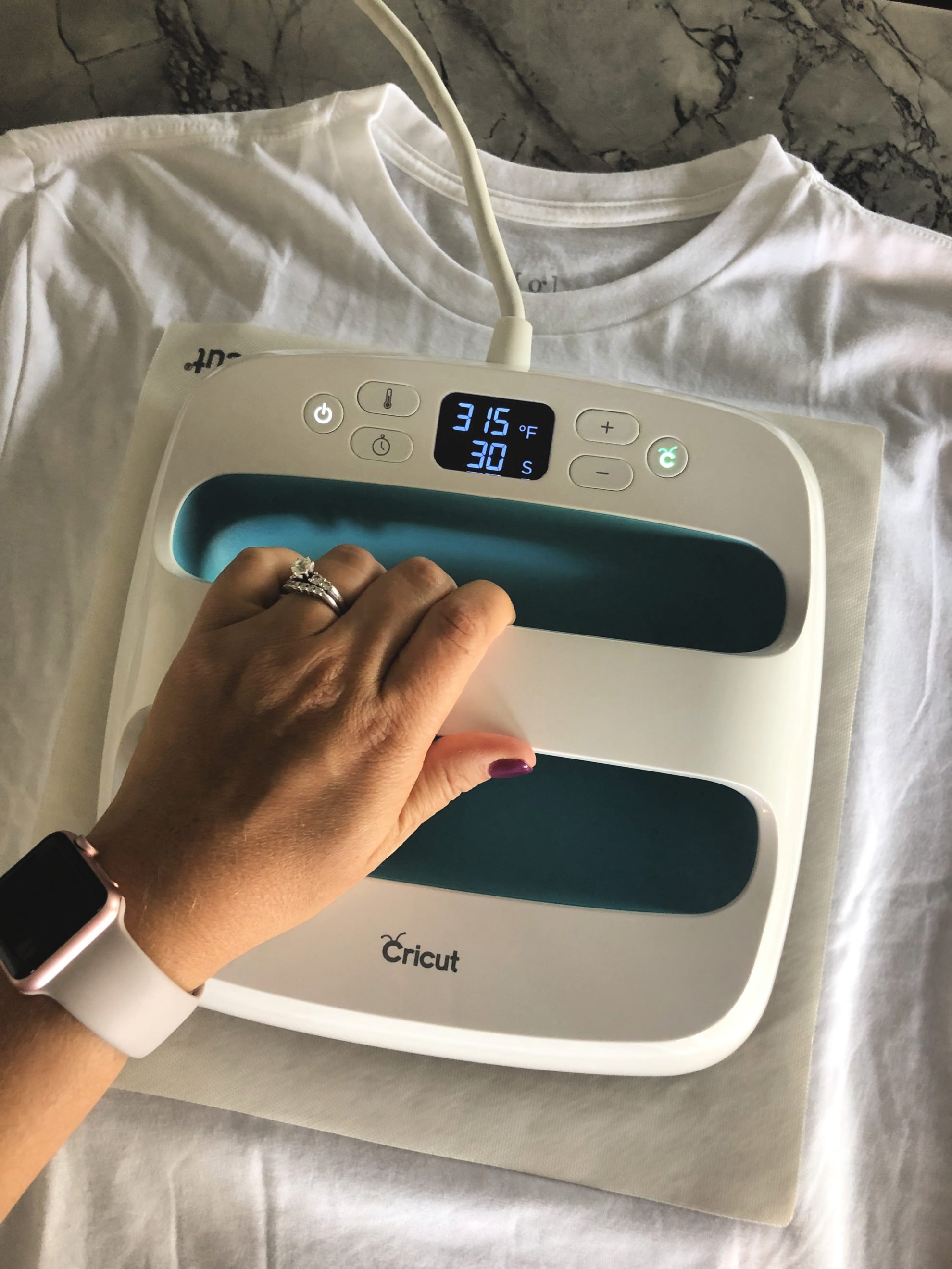 Top view of a Cricut EasyPress on top of a white tshirt.