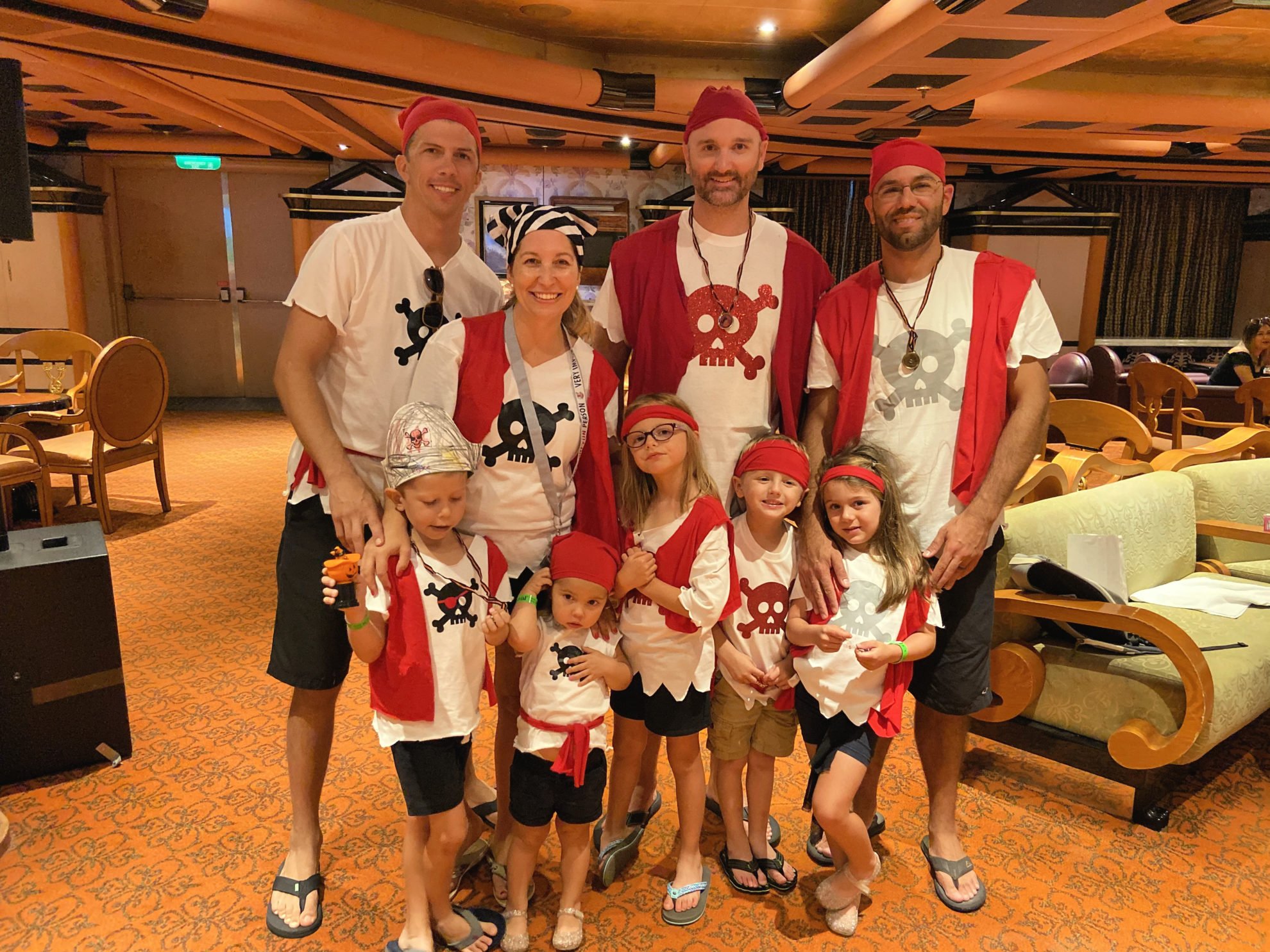 Men and women with children all dressed in a pirate shirt.