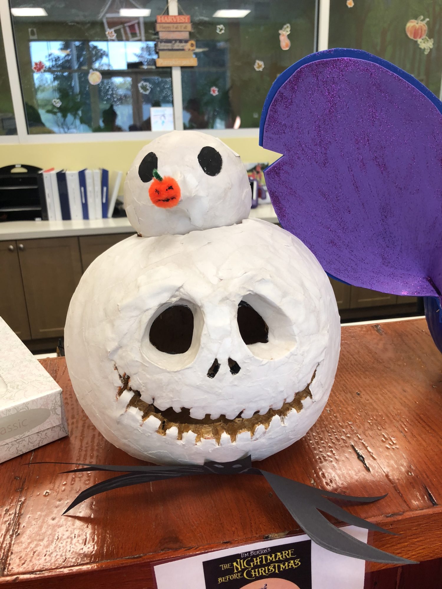 Jack Skellington carved pumpkin with his dog on top all painted in white.