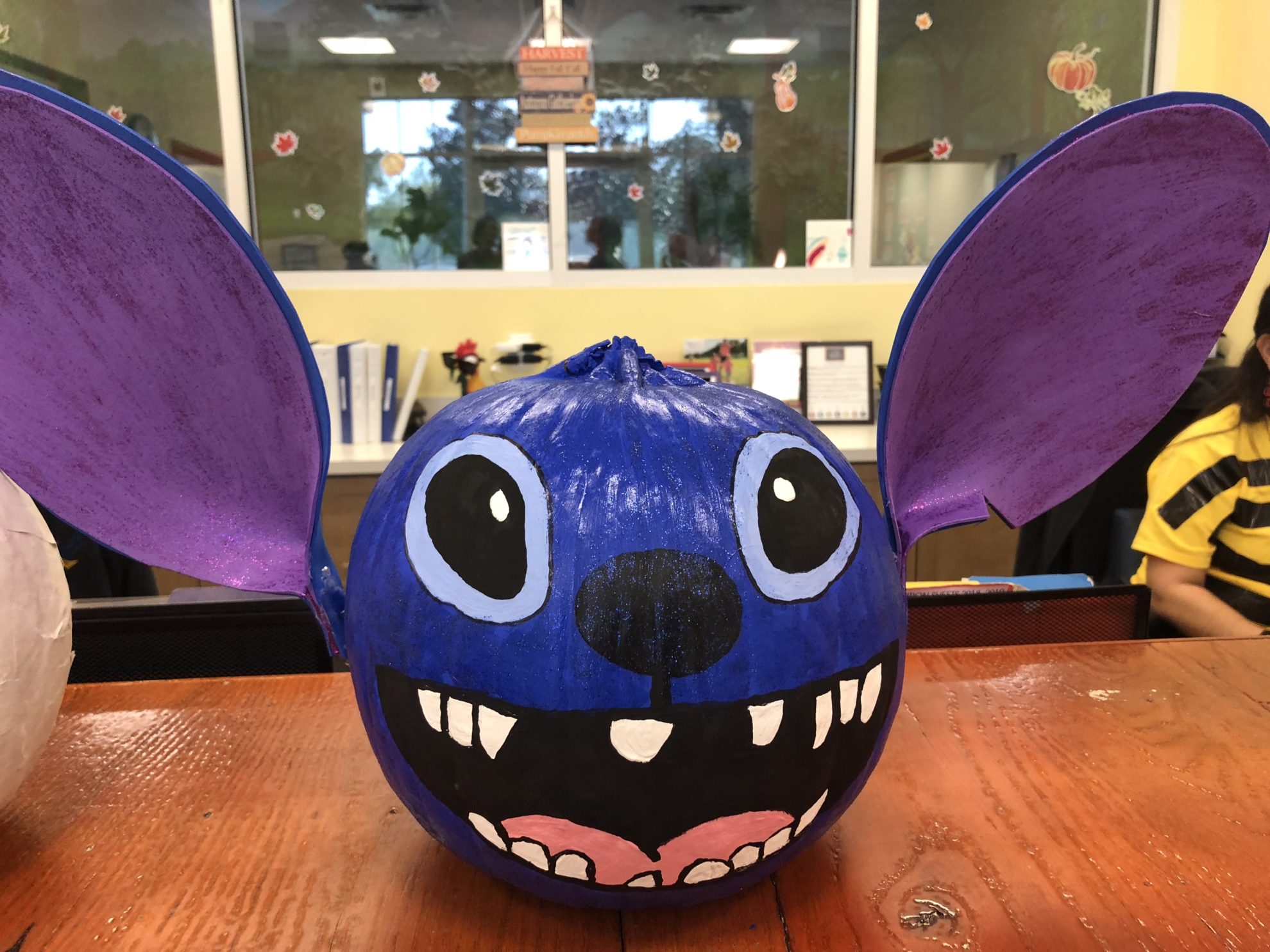 Bright blue painted Stitch pumpkin with foam ears.