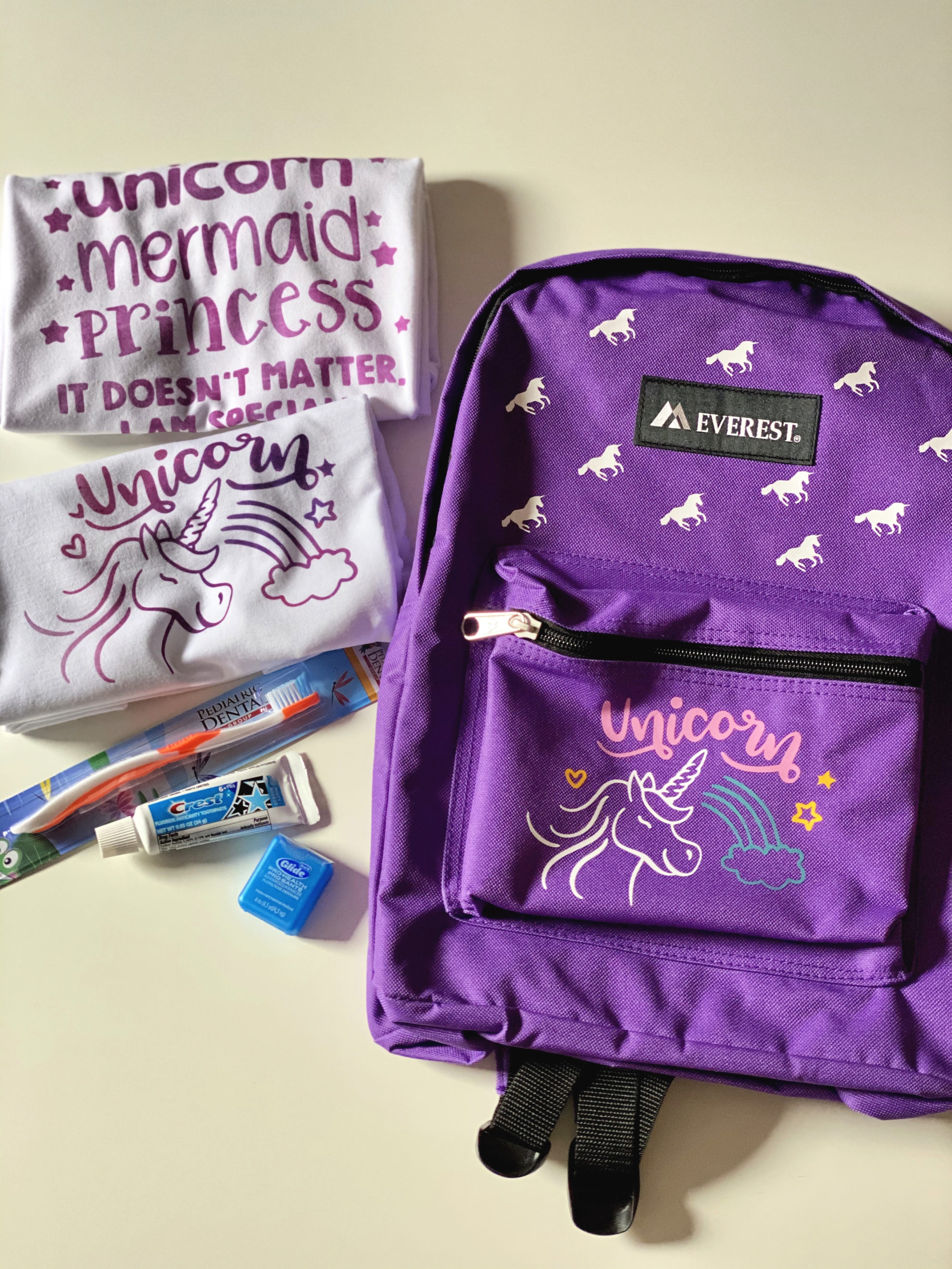 Purple Mermaid Backpack with unicorn shirts and toiletries. 