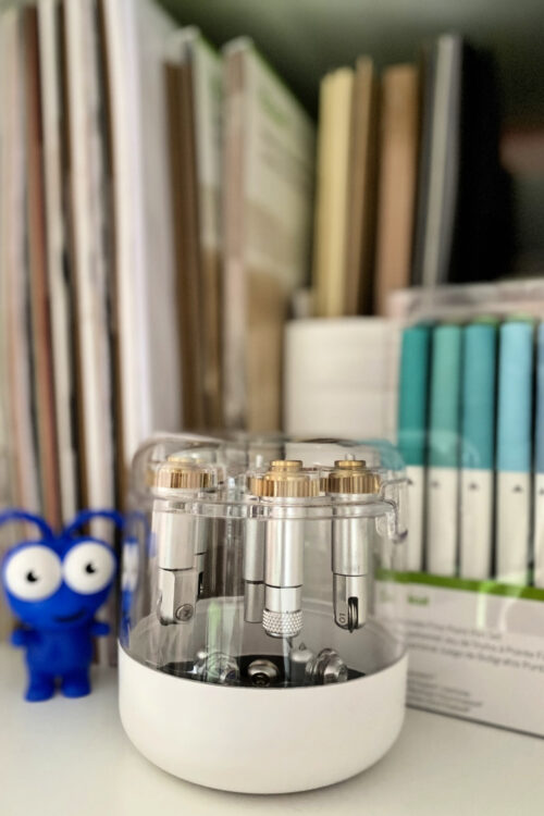 Photo of the Cricut Machine Tool Oragnizer on a craft shelf with pens in the background.