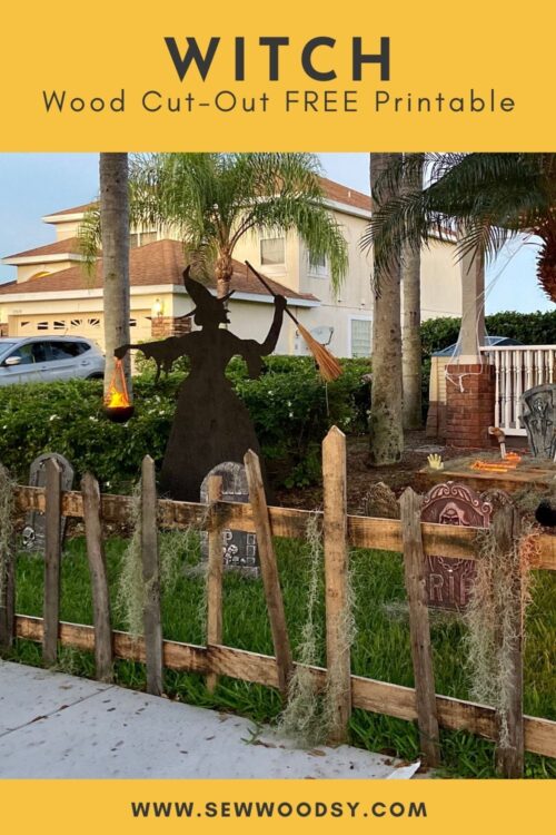 Wood pickett fence with a black silhouette witch in the background.