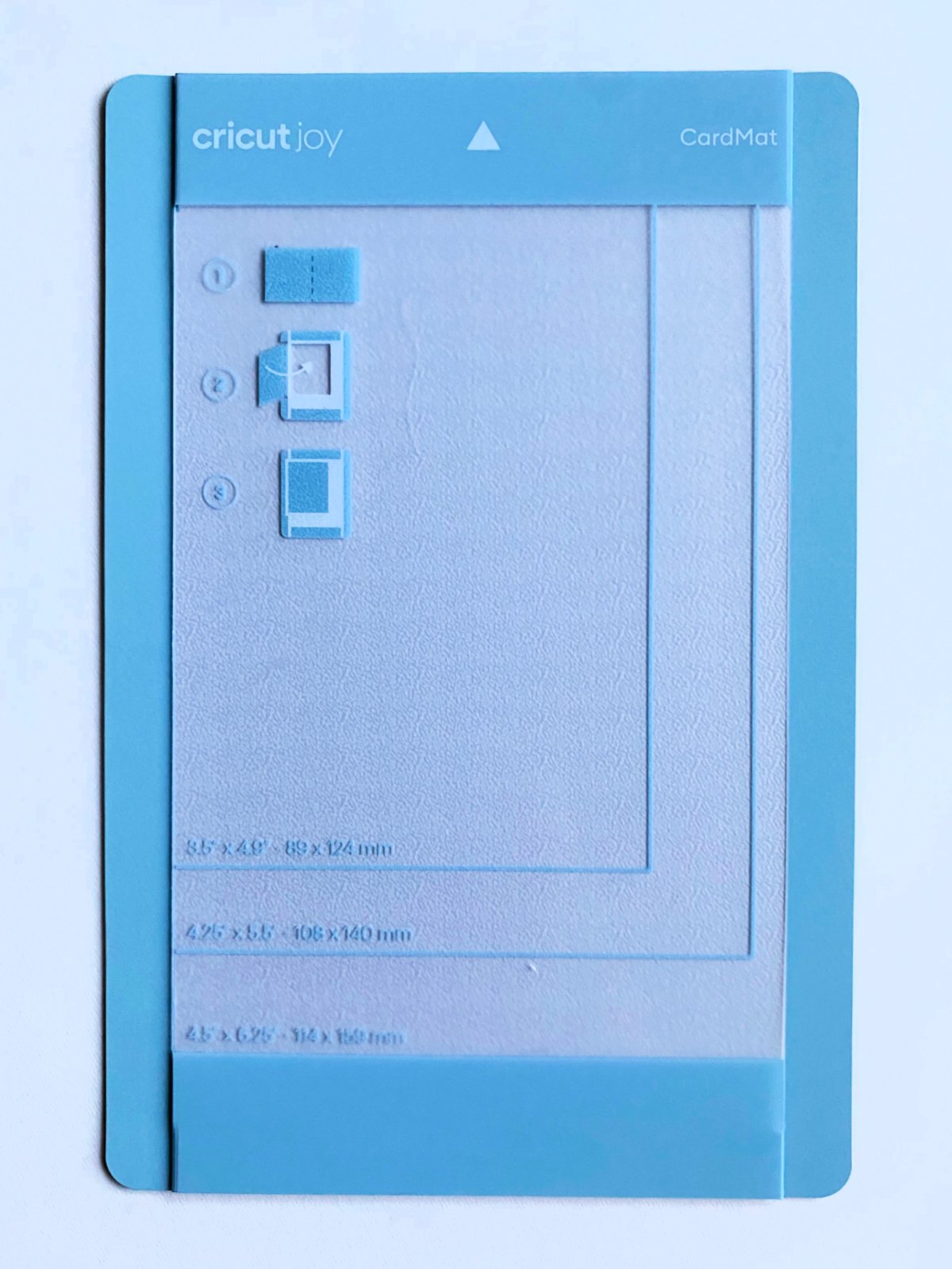 Small light blue Cricut Joy CardMat on a white surface.