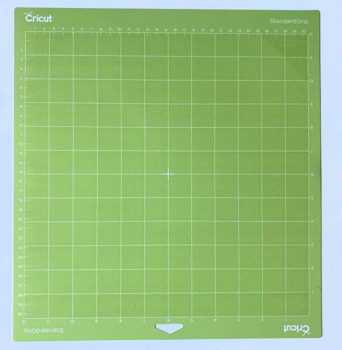Neon green Cricut StandardGrip Mat on a white surface.