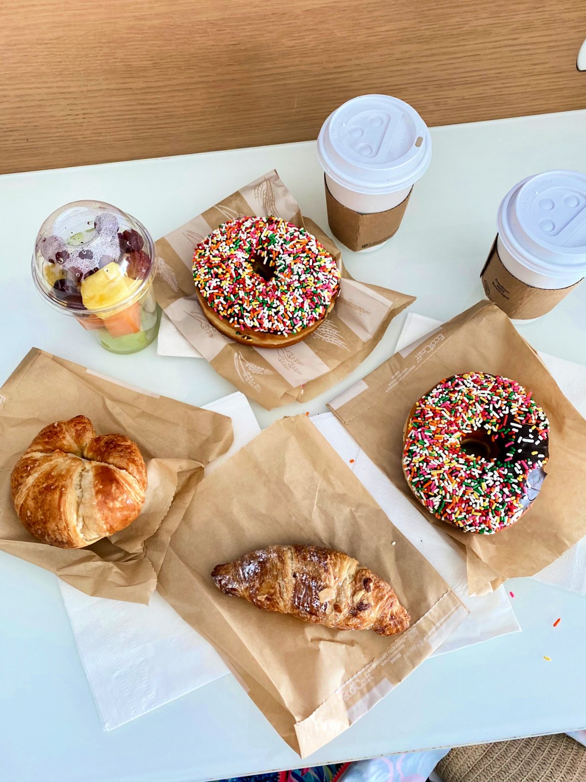 2 donuts, 2 coffees, fruit cup, and croissant.