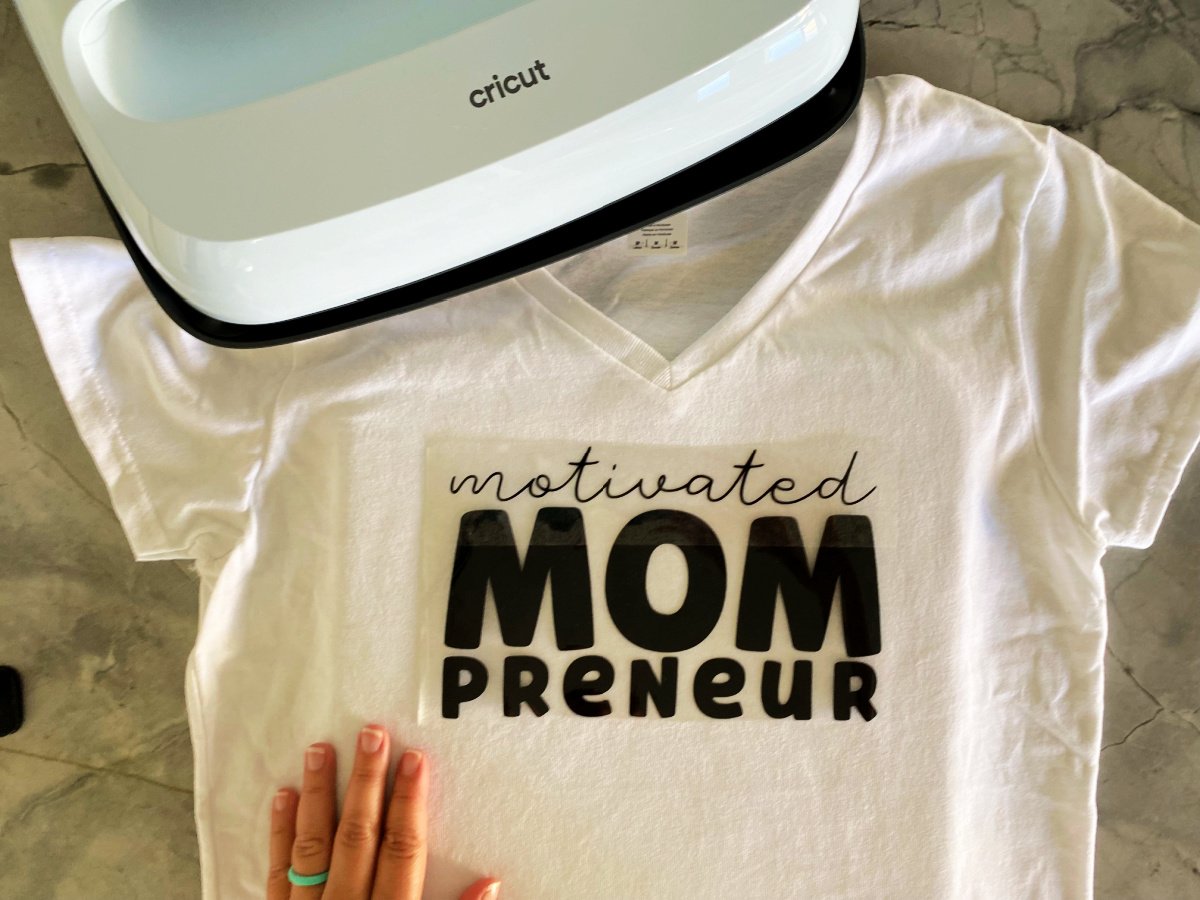 White shirt with motivated mompreuner on plastic on top.
