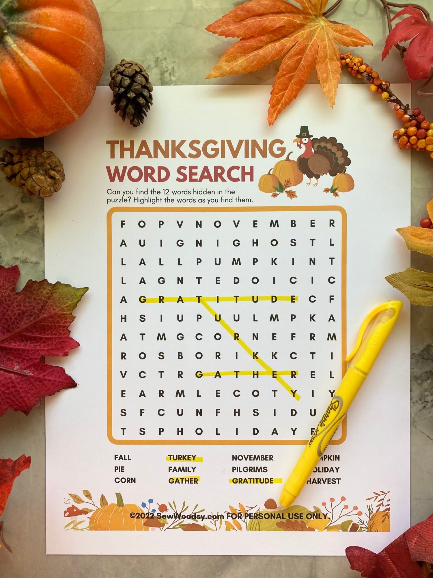 White print out paper of a wordsearch with a pumpkin and fall leaves next to it.