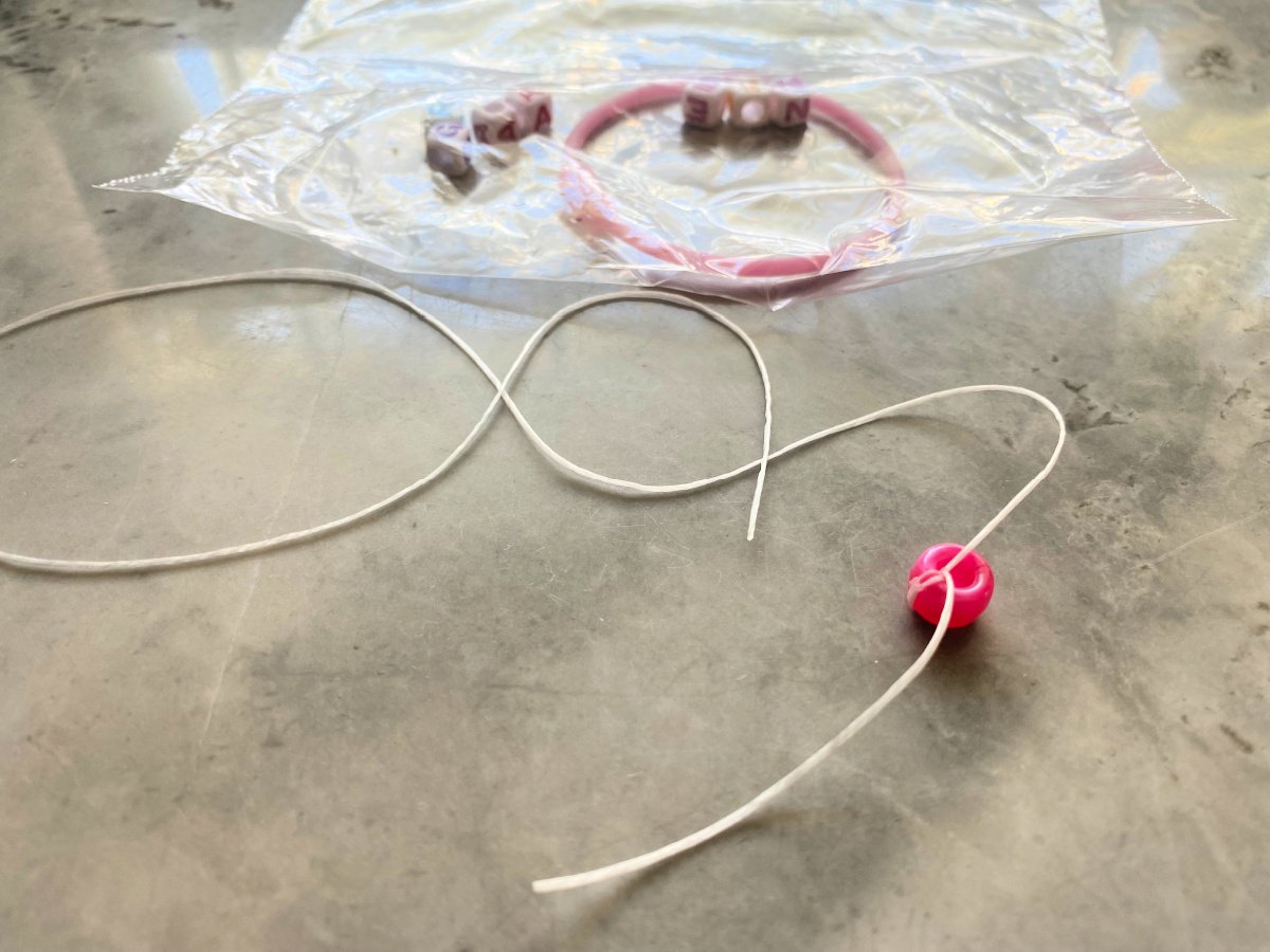 Bead tied on elastic necklace on a countertop.