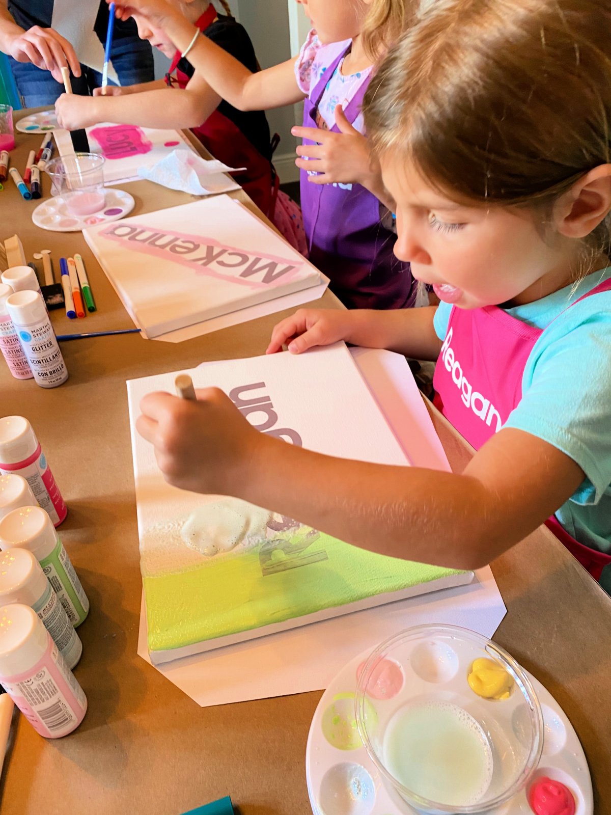 Little girl painting on a canvas.