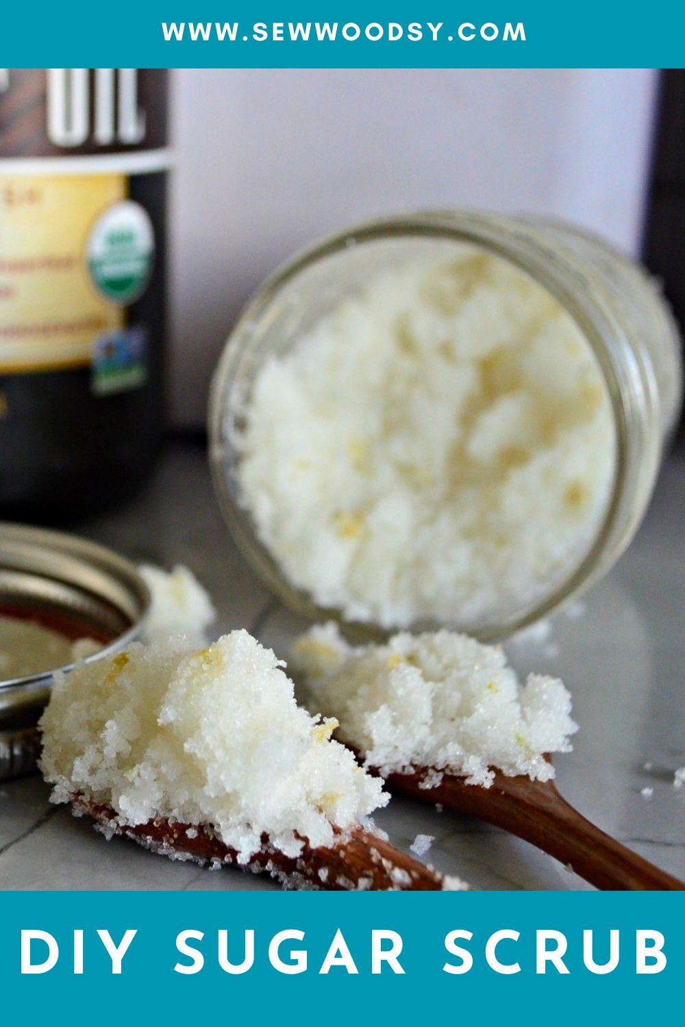 Two wooden spoons with sugar scrub on them with a jar in the background with recipe title text on image for Pinterest.