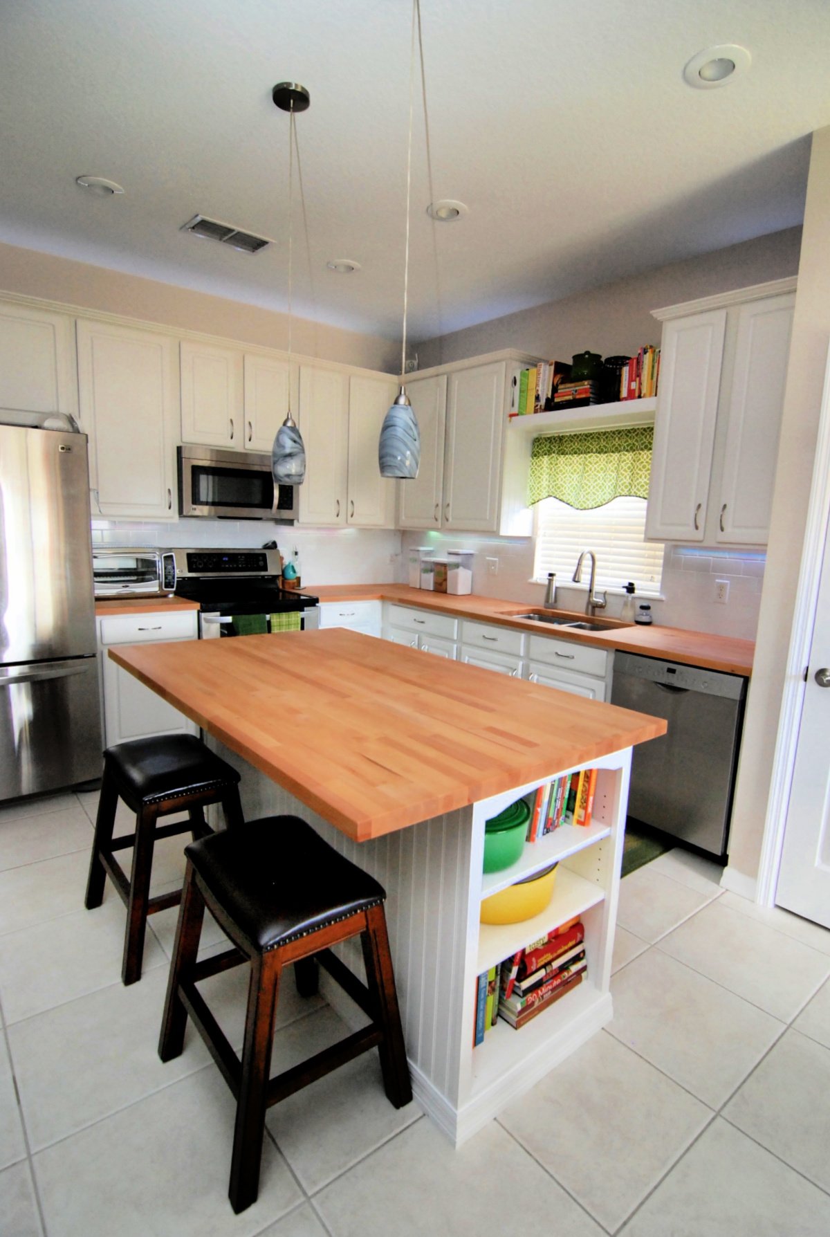 White kitchen with light wood butcher block countertops.