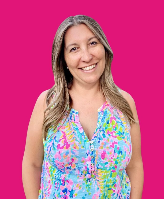 Female in bright colored shirt with pink background.