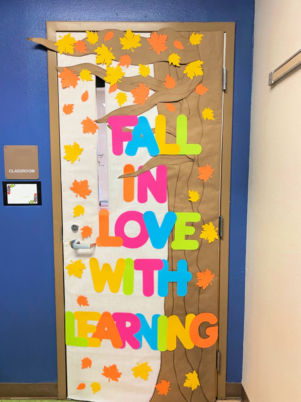 Large tree with fall leaves and the words "fall in love with learning"