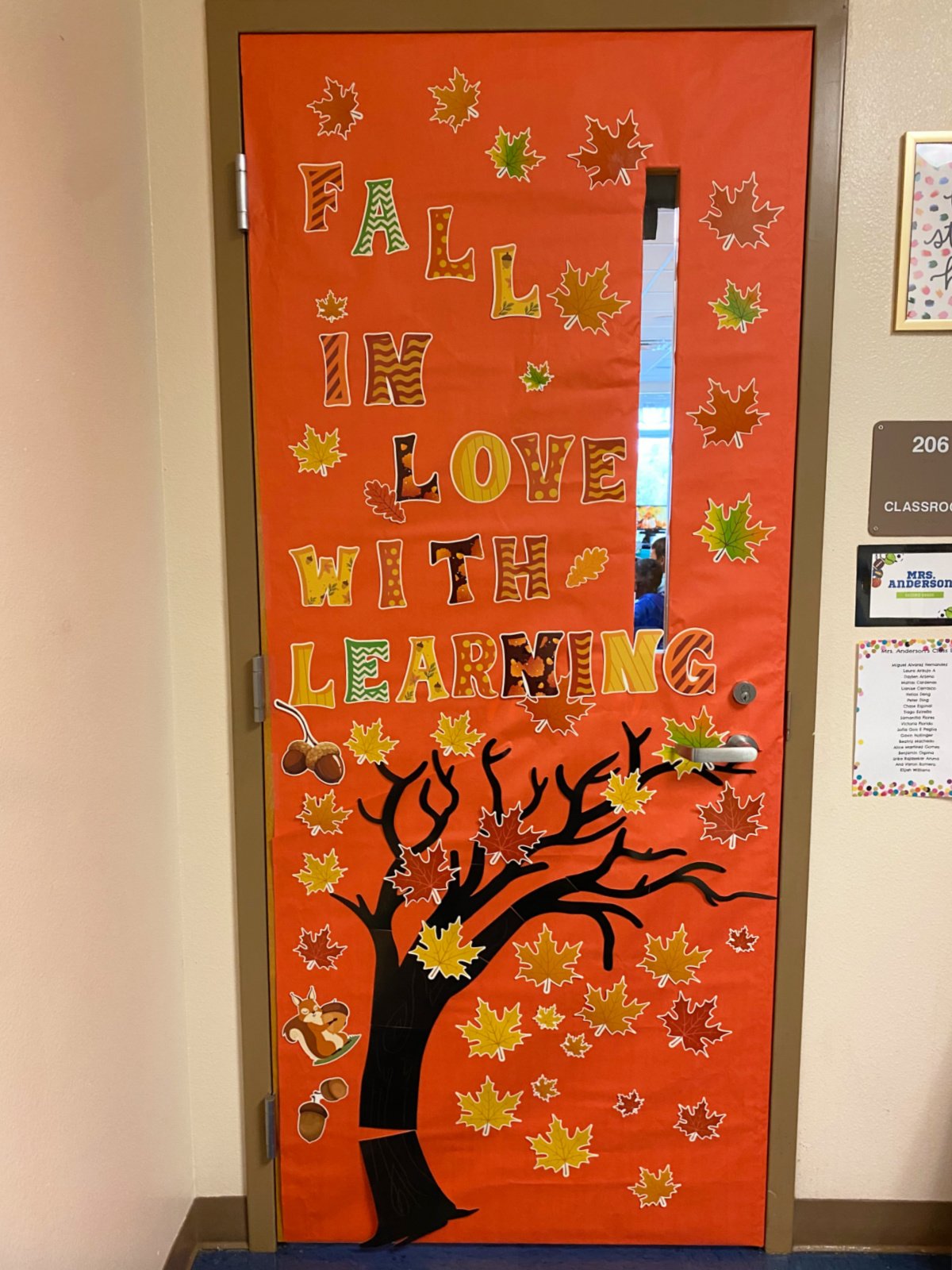 Orange classroom door with tree and fall leaves.