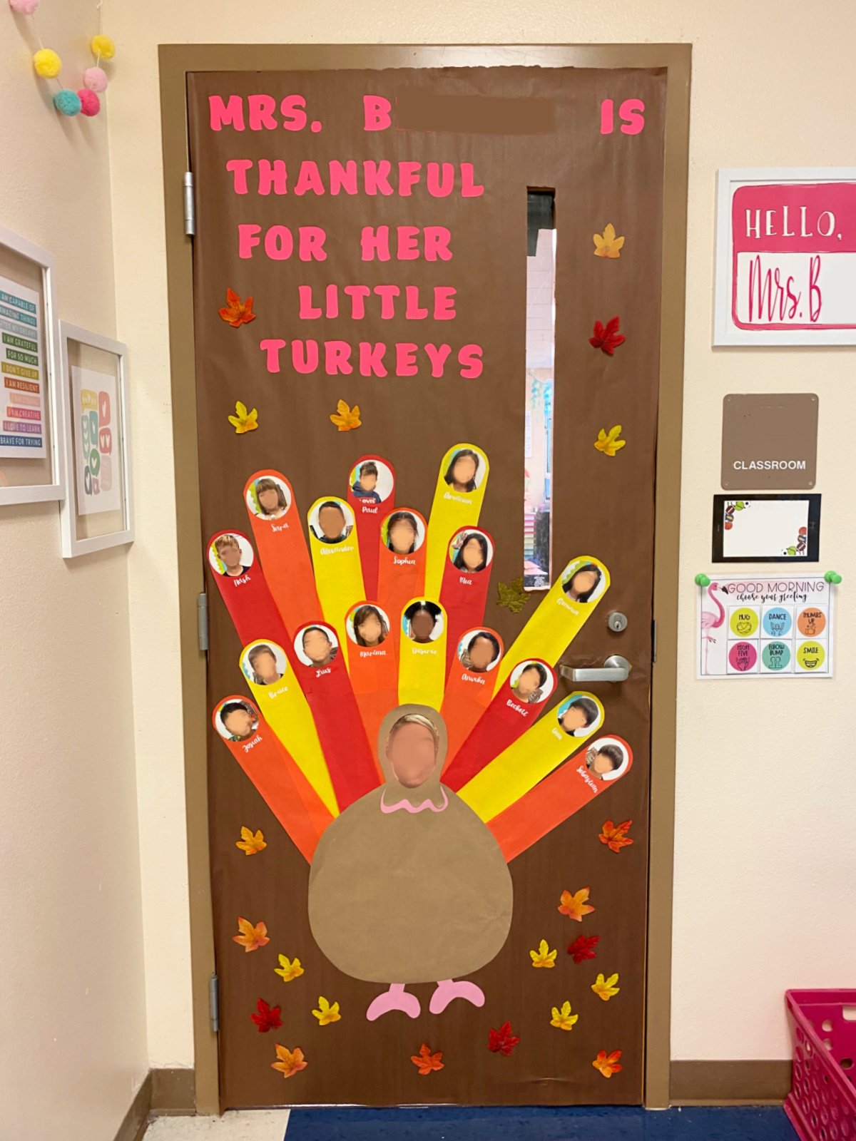 Classroom door with brown background a large turkey with a teachers face on it and students face on feathers with names.