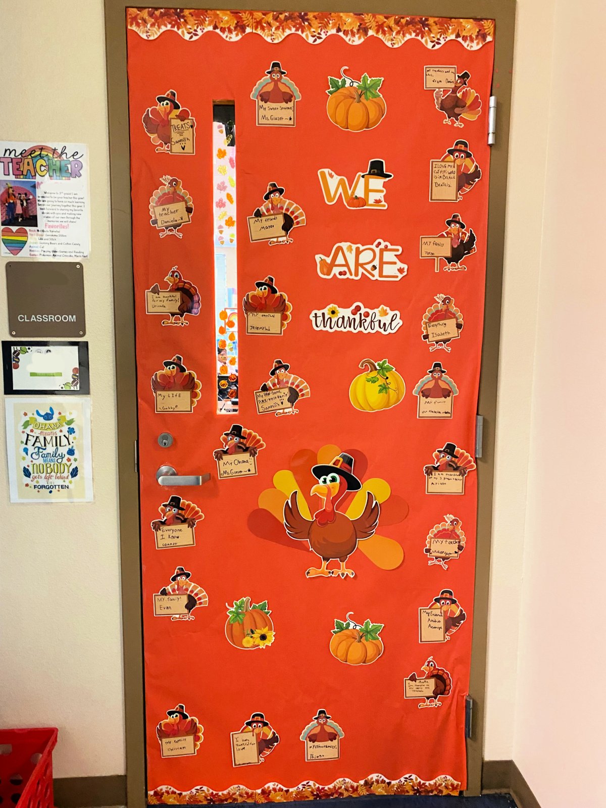 Orange classroom door with turkeys that say what they are thankful for.