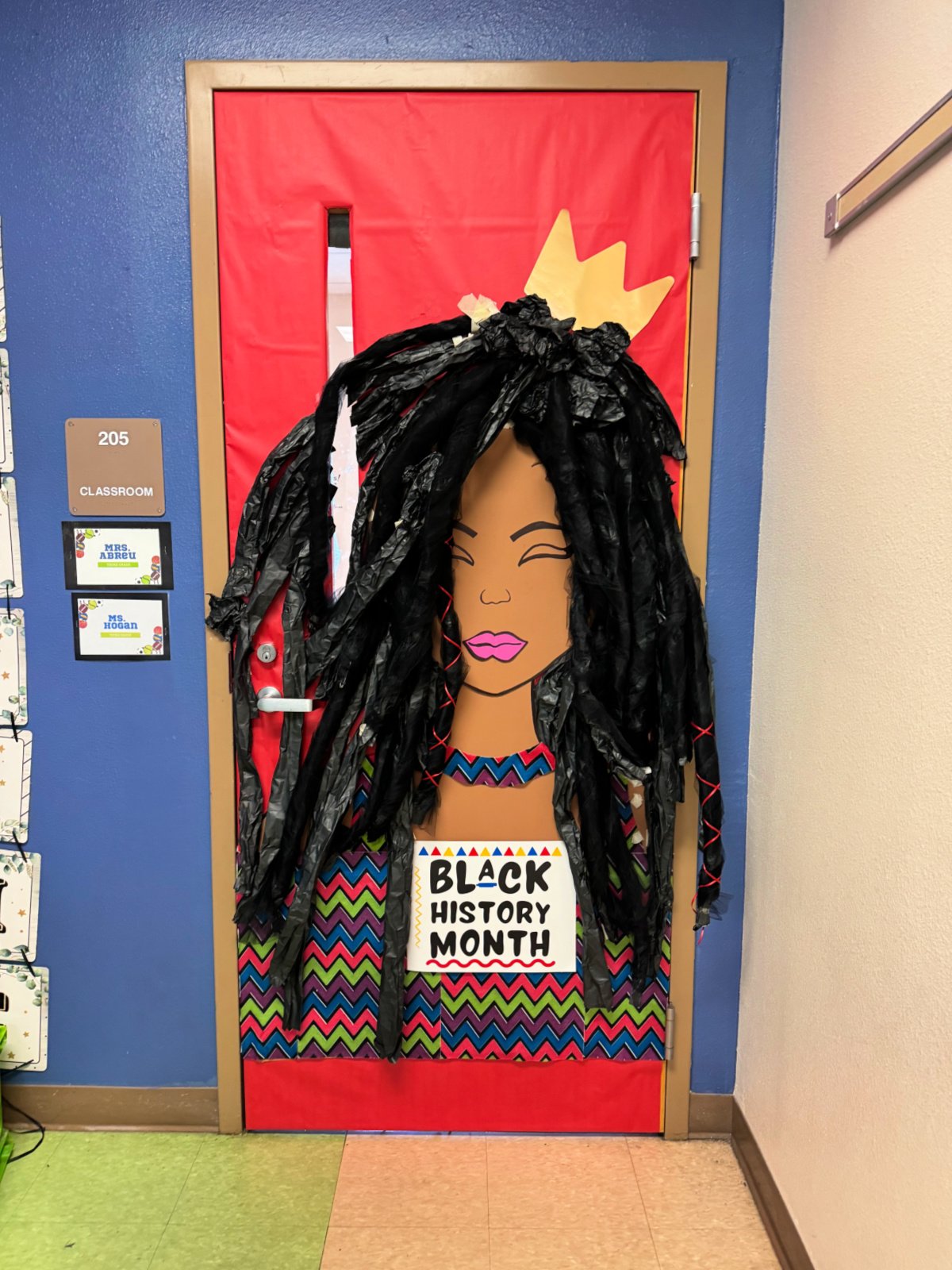 Red door with african american woman with dreadlocks and a sign that reads Black History Month.