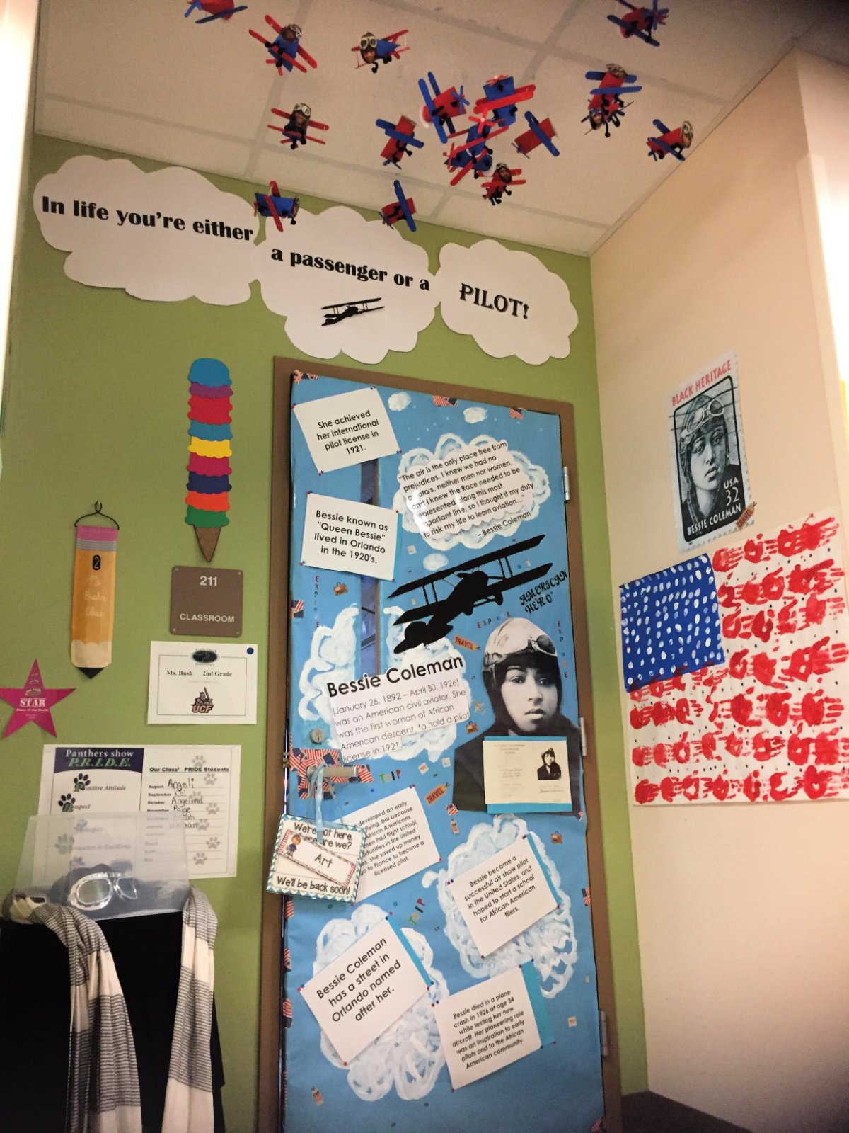 Bessie Coleman on the door with blue paper and clouds.