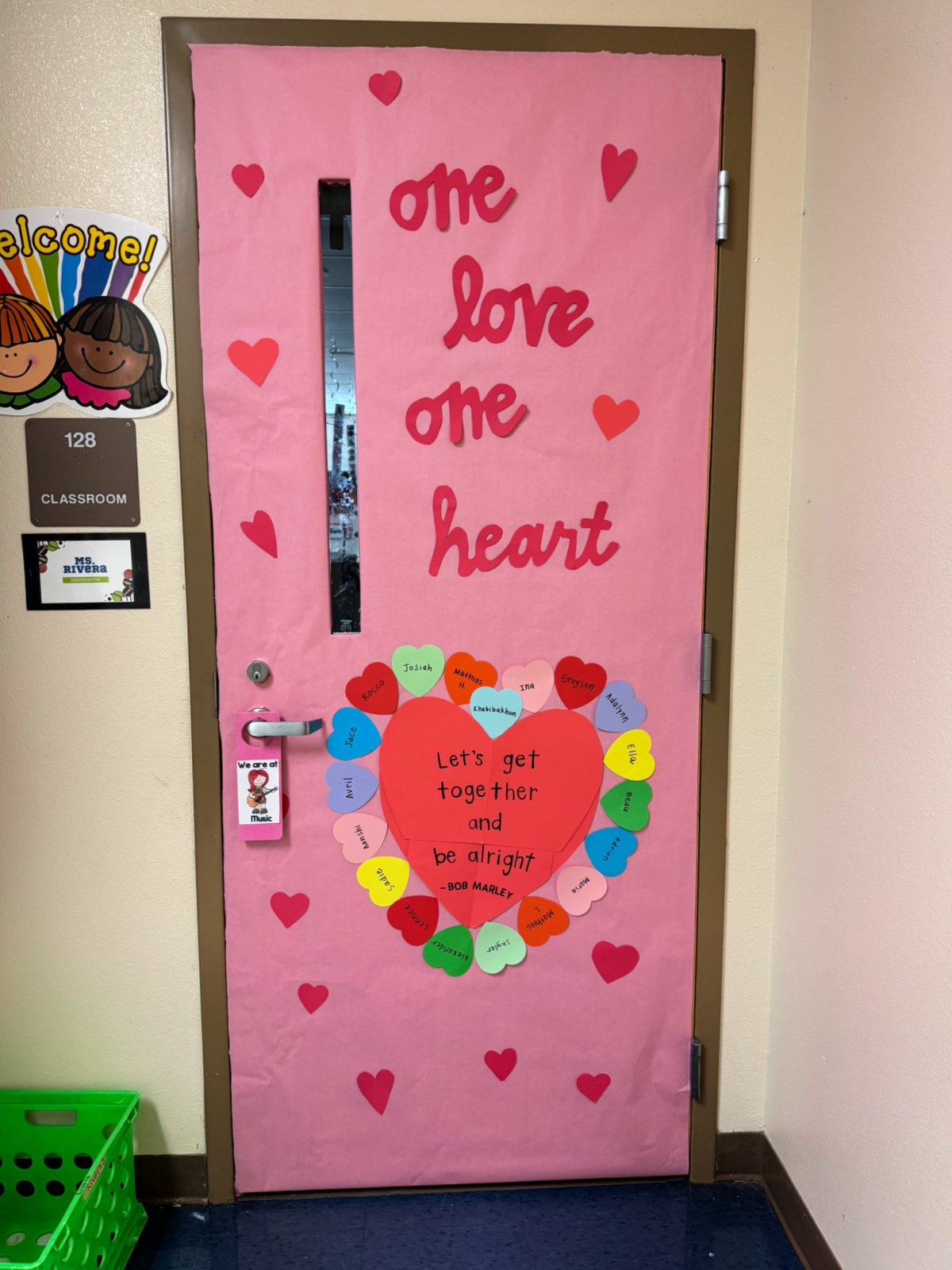 Pink door with "one love one heart" and hearts with kids names on it.
